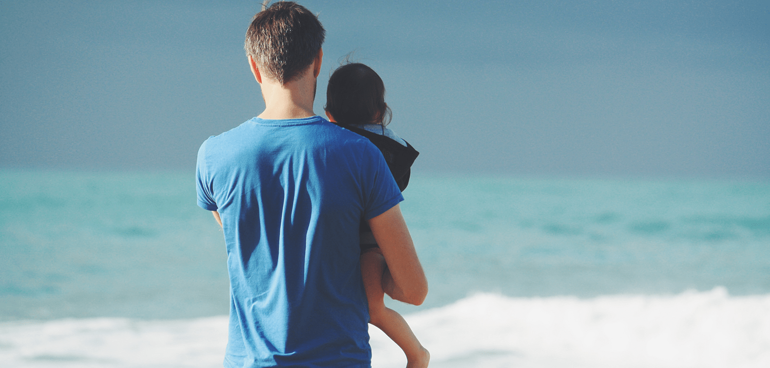 father-holding-child-at-the-beach